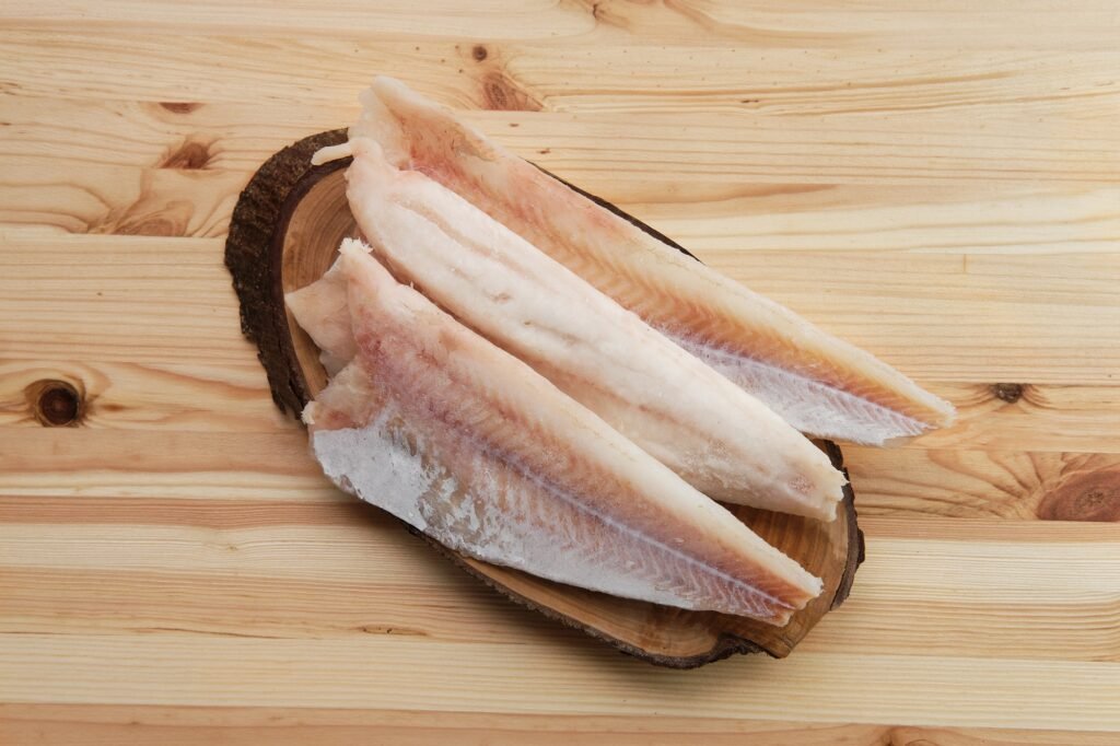 Frozen fillet of pangasius on wooden plate