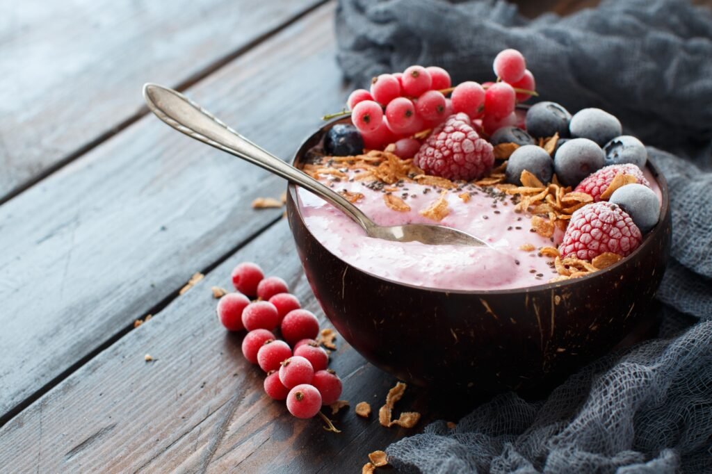 Wild berries smoothie bowls topped with frozen berries and granola